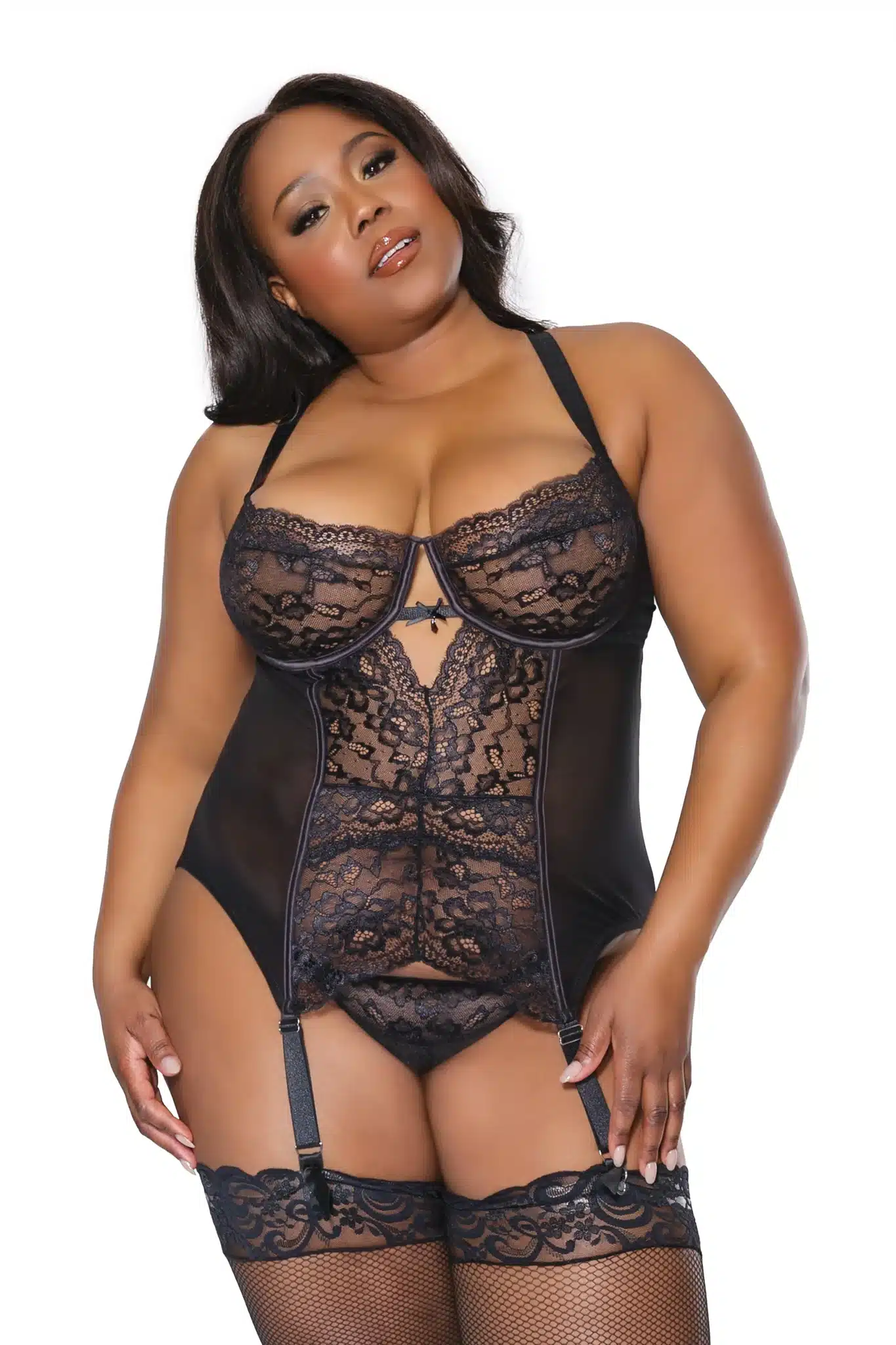 Brunette woman wearing a sheer and lace black bustier and black thong and stockings